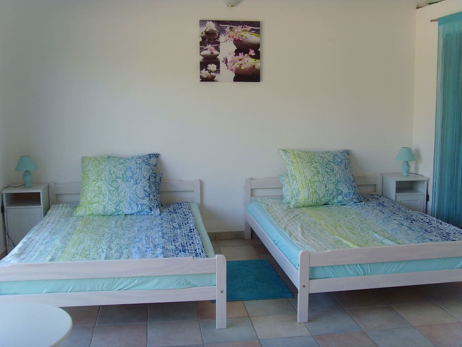 Schlafzimmer mit Kingsizebetten und begehbarem Kleiderschrank, mit Duschbad