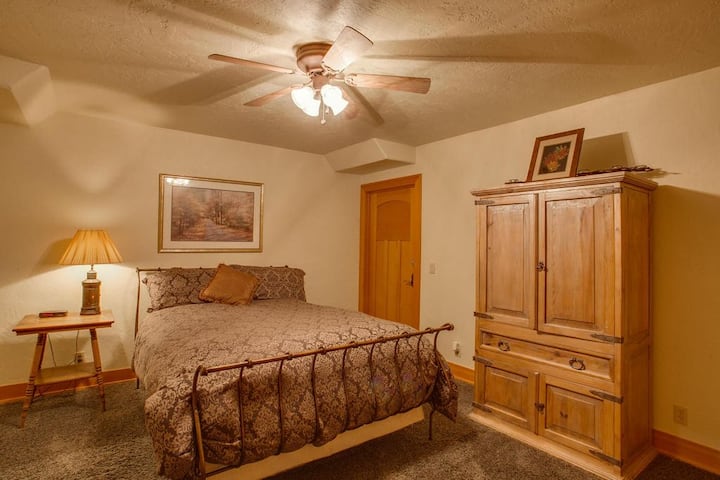 Fourth private bedroom downstairs features a queen size bed, closet and adjacent bathroom.