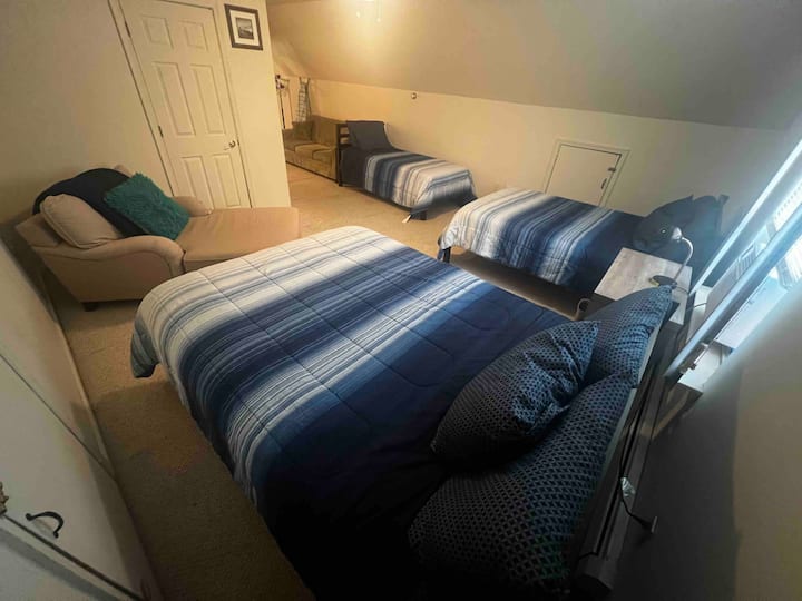 Dormitorio grande, con 2 camas tamaño queen, 1 individual y un sofá de tres plazas.