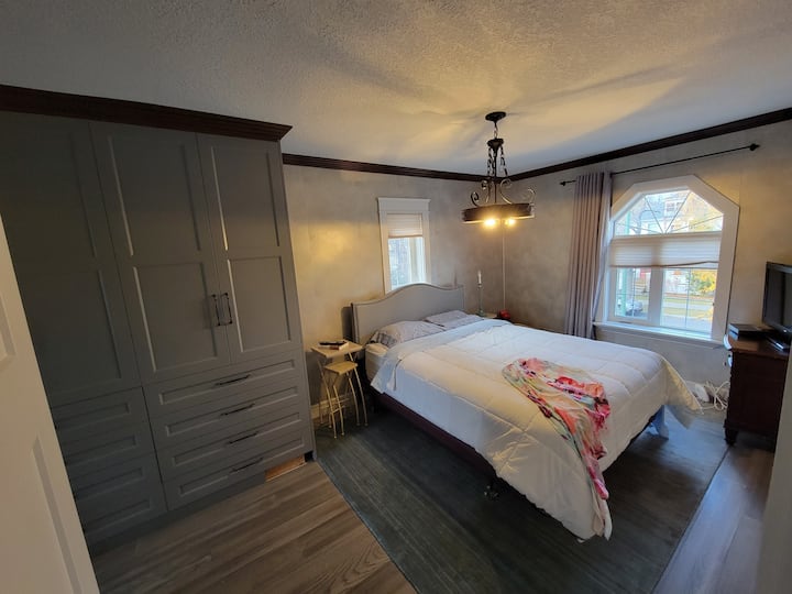 Chumba chetu kikuu cha kulala kinatoa sehemu ya kukaa ya kifahari: matandiko ya starehe, televisheni, kabati la nguo - hata mashine ya kufulia/kukausha ya ndani. 