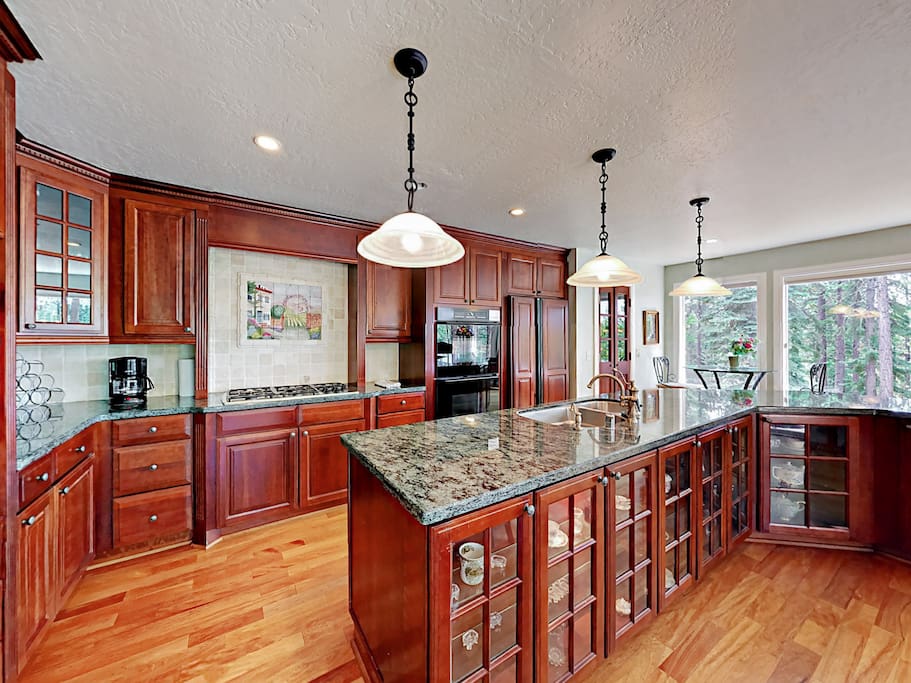 The gourmet kitchen features dark cherry cabinets, granite countertops, and high-end appliances.
