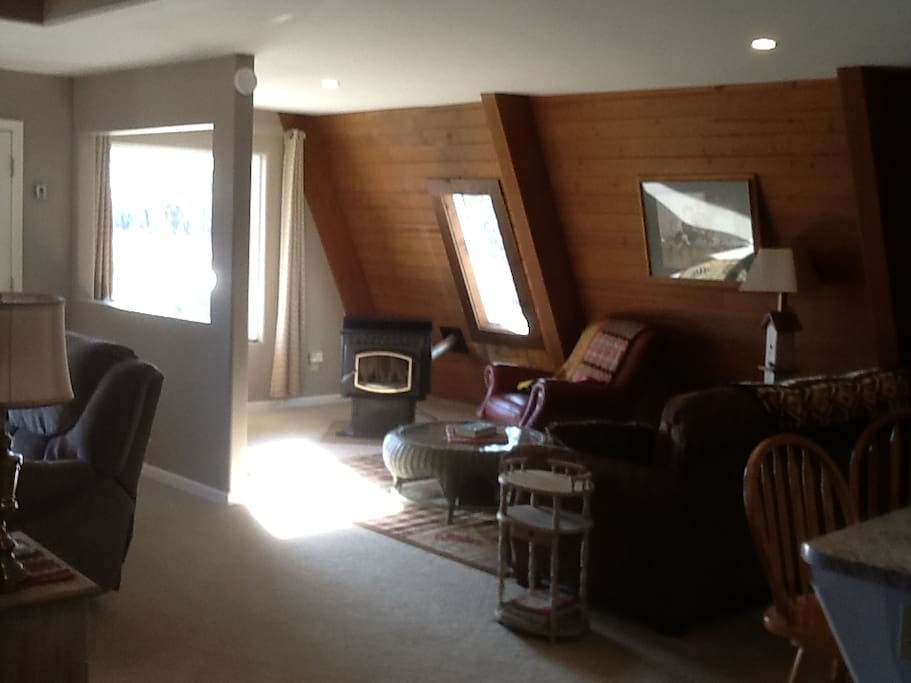 Window view of lake, sofa and chairs.