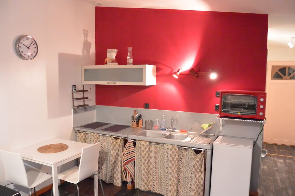 Une cuisine avec réfrigérateur, four, table à induction et