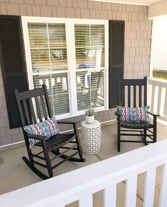 The front porch has four rocking chairs.