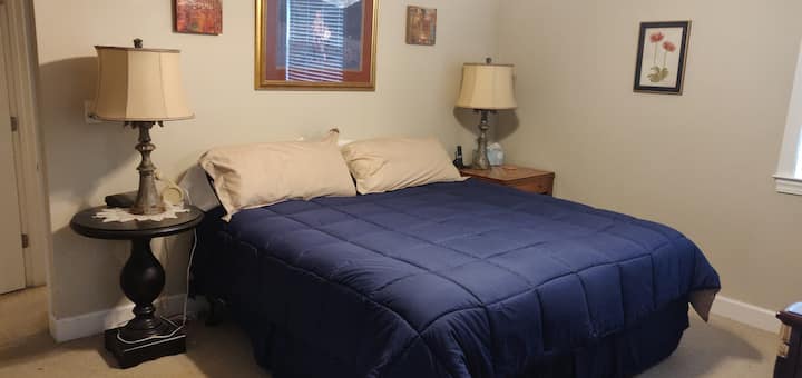 Dormitorio principal con cama tamaño king y TV de 40 pulgadas por cable.  La suite incluye sala de estar separada con asiento de amor y escritorio.
