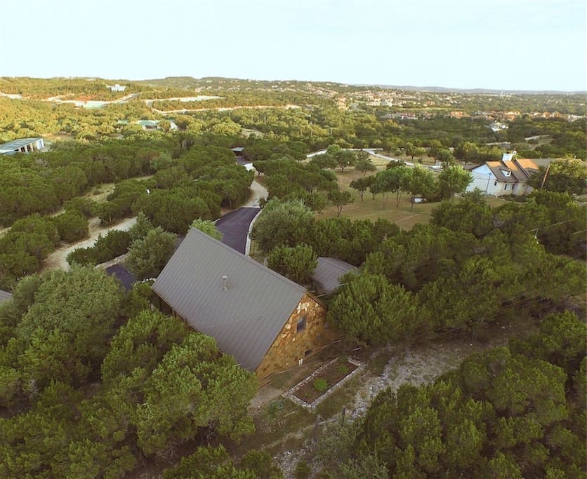 An aerial view of the Storybook Cottage & hill country beyond. The owners' main house is top right.