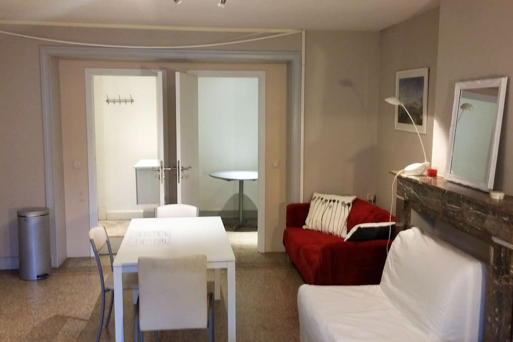 Dining table and sofas (doors of bathroom and closet open)