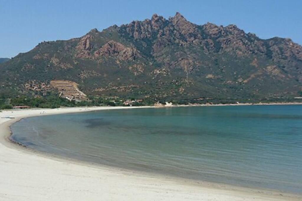 acqua trasparente dal fondale bassa con sabbia fine e vista monte Ferru