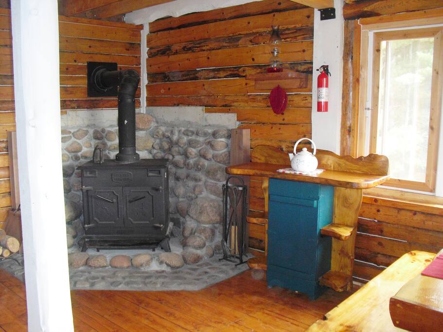 The woodstove's doors open to allow a screen to be put in to watch the fire.