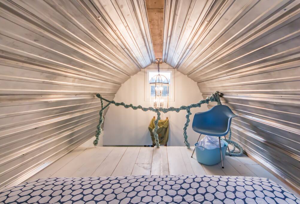 Rustic and cozy loft with king bed, up-cycled steel ceiling and his and her's reading lights.