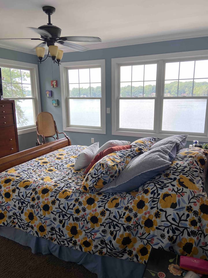 Master bedroom with views of Pine Lake #2.  Queen sized bed.  Rocking chair.  Attached full bathroom.