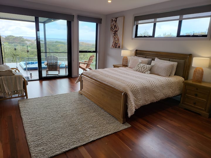Dormitorio 1 dormitorio principal en la planta baja con cama tamaño king, TV inteligente en línea, bata y baño privado, que se abre a la terraza del spa.