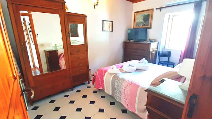 Lichte slaapkamer met tweepersoonsbed,tent en raam, tv, ventilator met peddel, airconditioning, 2 nachtkastjes,abat jour,kledingkast en dressoir.
High bad.