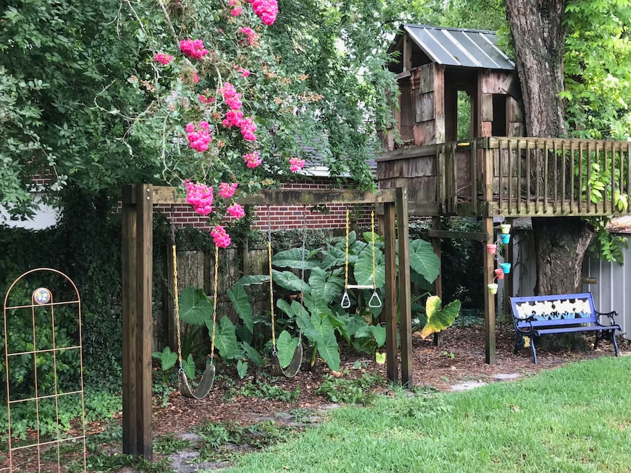 Swing set and tree house in back yard