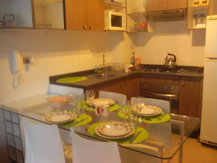 Cocina equipada con cocina a gas, horno eléctrico, horno microondas, refrigerador, baterias de cocina y vajilla completa para hasta 6 personas.