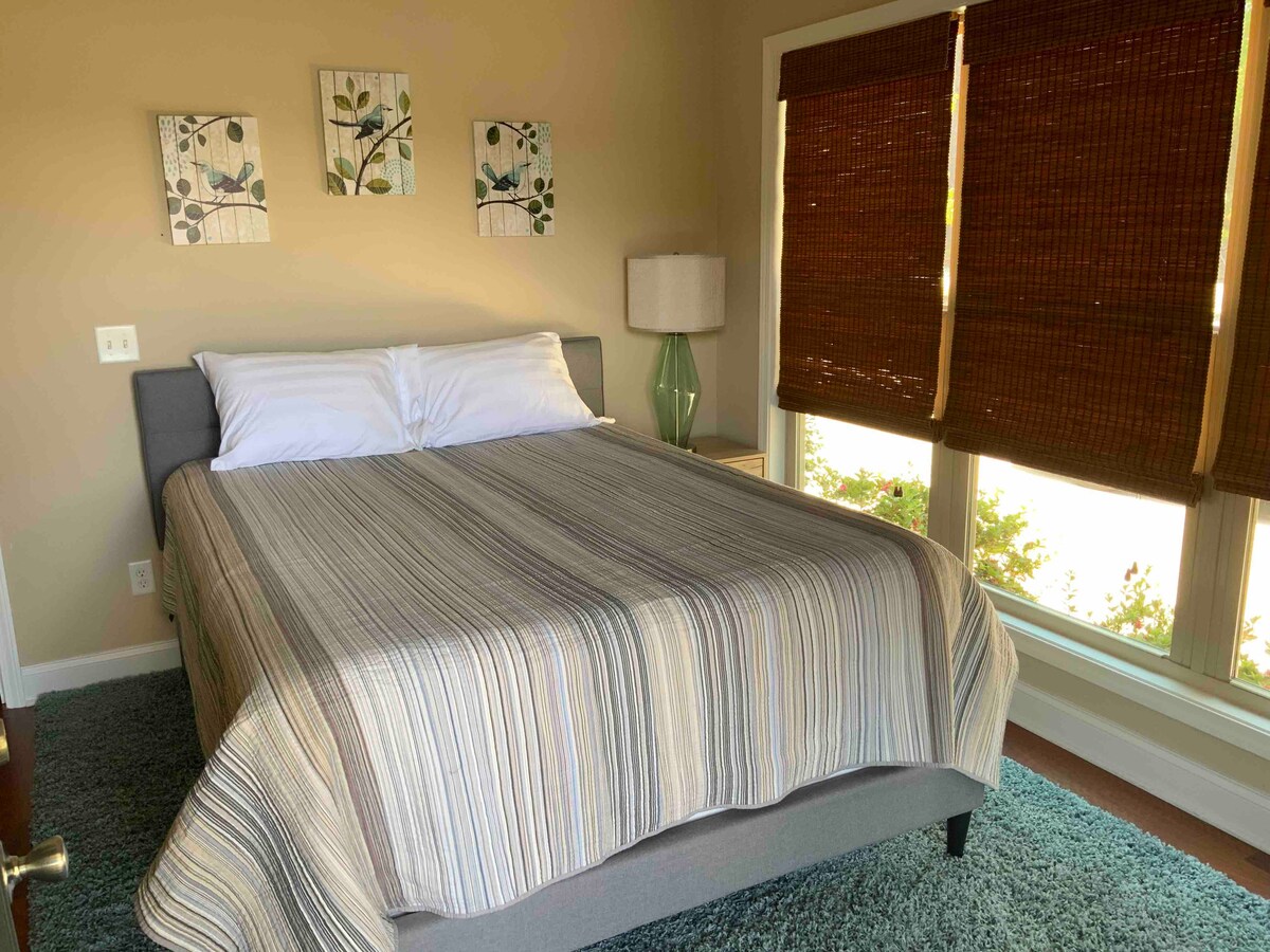 Druhá spálňa na hlavnom poschodí s manželskou posteľou Queen a vchodom/východom na zadnú terasu a výhľad na jazero