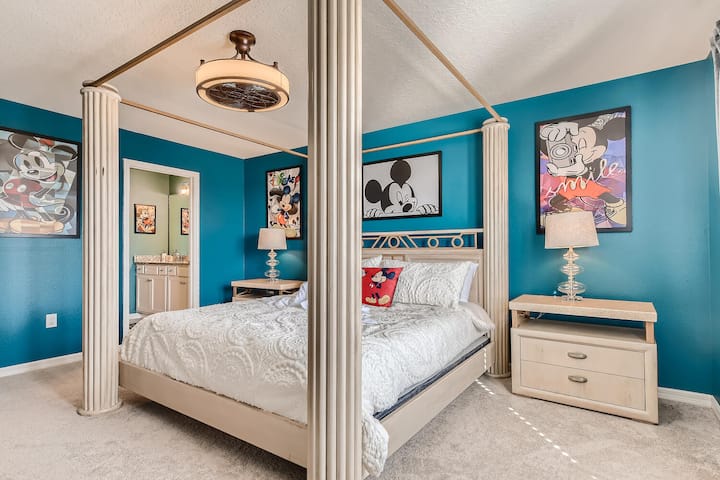 Mickey-themed master bedroom with king bed and private bath, overlooking the pool