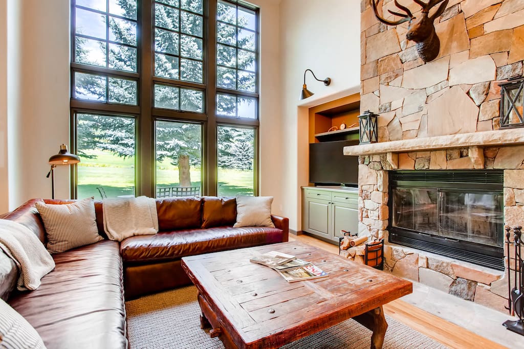 Living room with wood-burning fireplace & golf course views