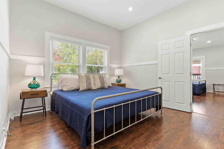 ห้องนอนนี้มีเตียงขนาดคิงไซส์โต๊ะข้างเตียงและโคมไฟ