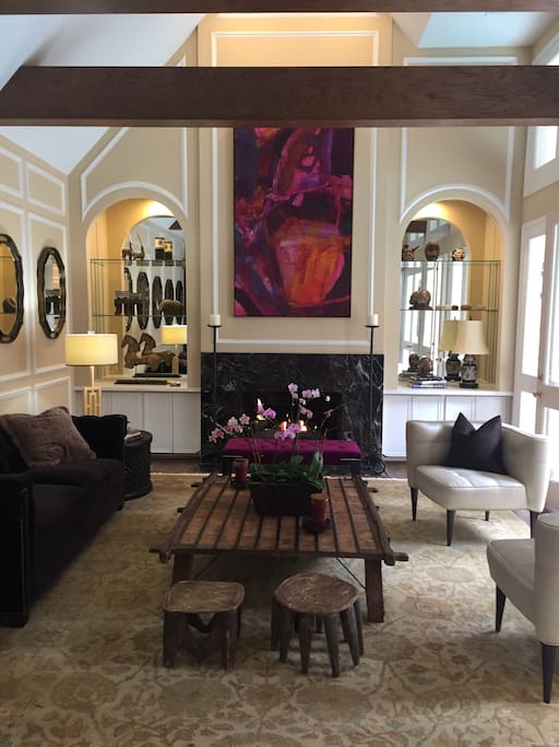 Stylish living room with vaulted ceiling and wooden beams. French doors lead to private interior courtyard.