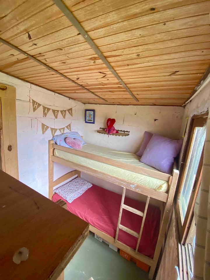 Izba s poschodovou posteľou a výhľadom na krajinu.