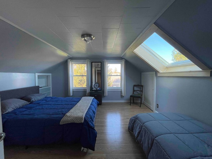 天窓と港の景色が見える広々とした2階のクイーンベッドルーム。