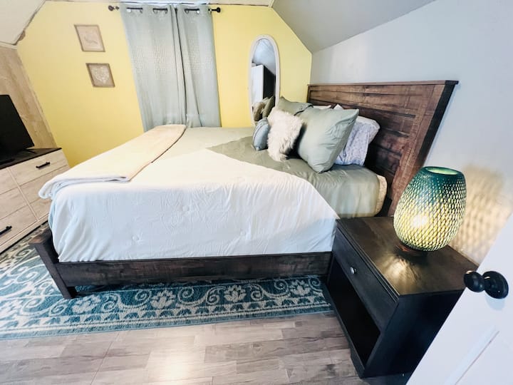 Hauptschlafzimmer. Genieße einen 55-Zoll-Flachbildschirm und Nachttisch mit Ladestation.