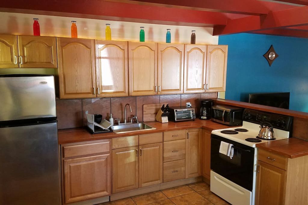 Kitchen with new appliances, toaster over, and microwave.
