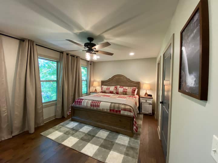 Upstairs king bedroom with private bath with tub shower, water views, closet, luggage rack, dresser, and tv. 