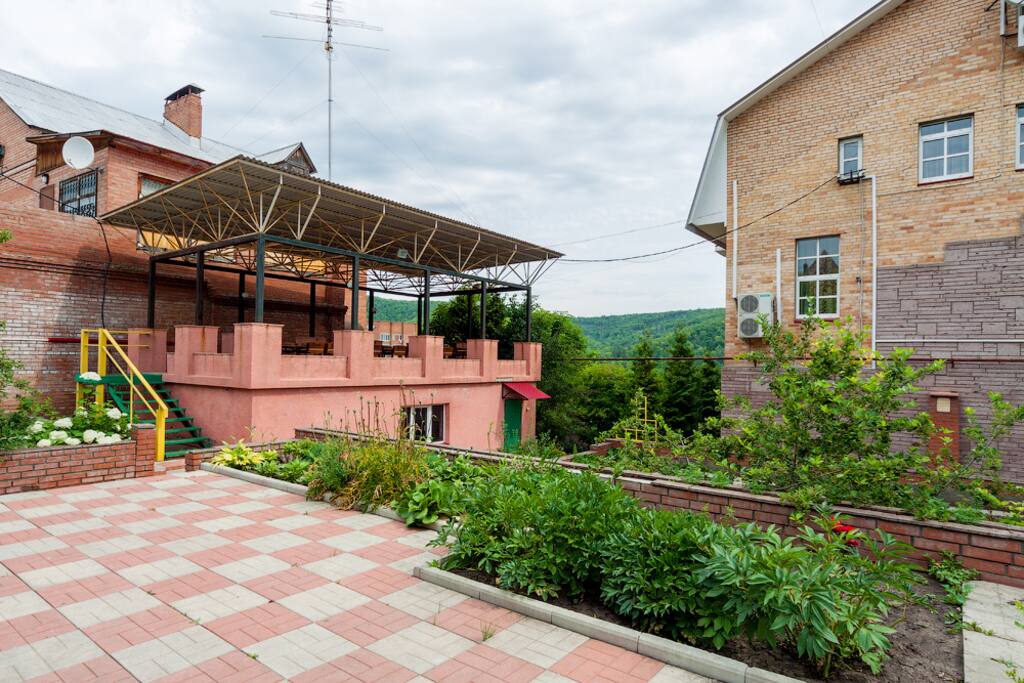 Двор с летней беседкой и зоной барбекю.