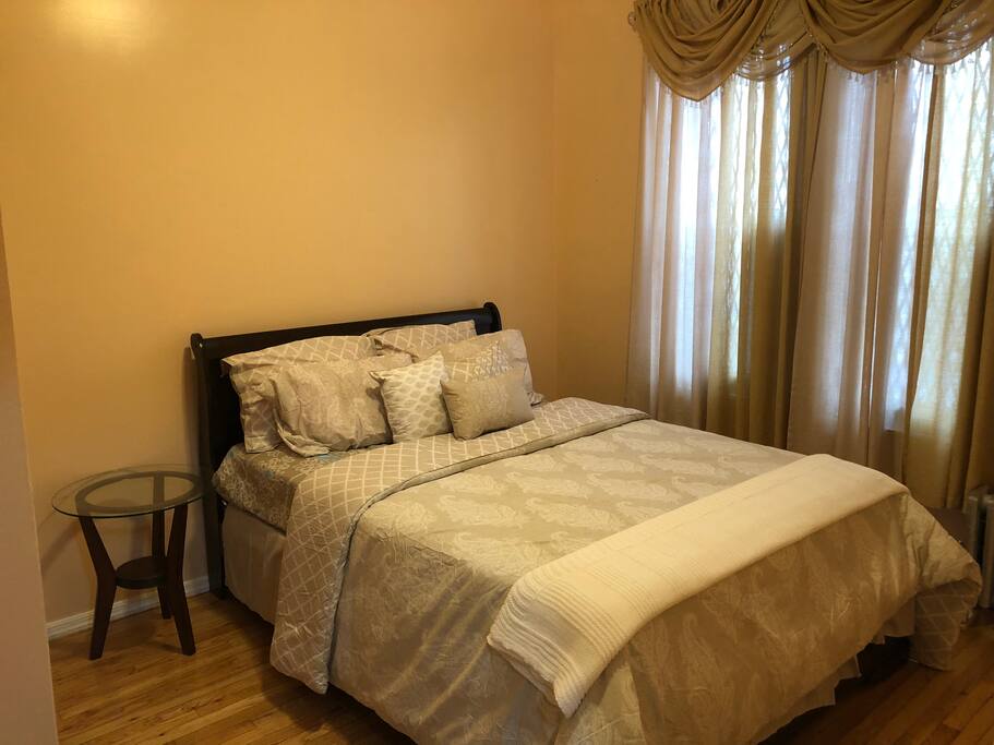 A very comfortable queen size bed in a simple decorative bedroom