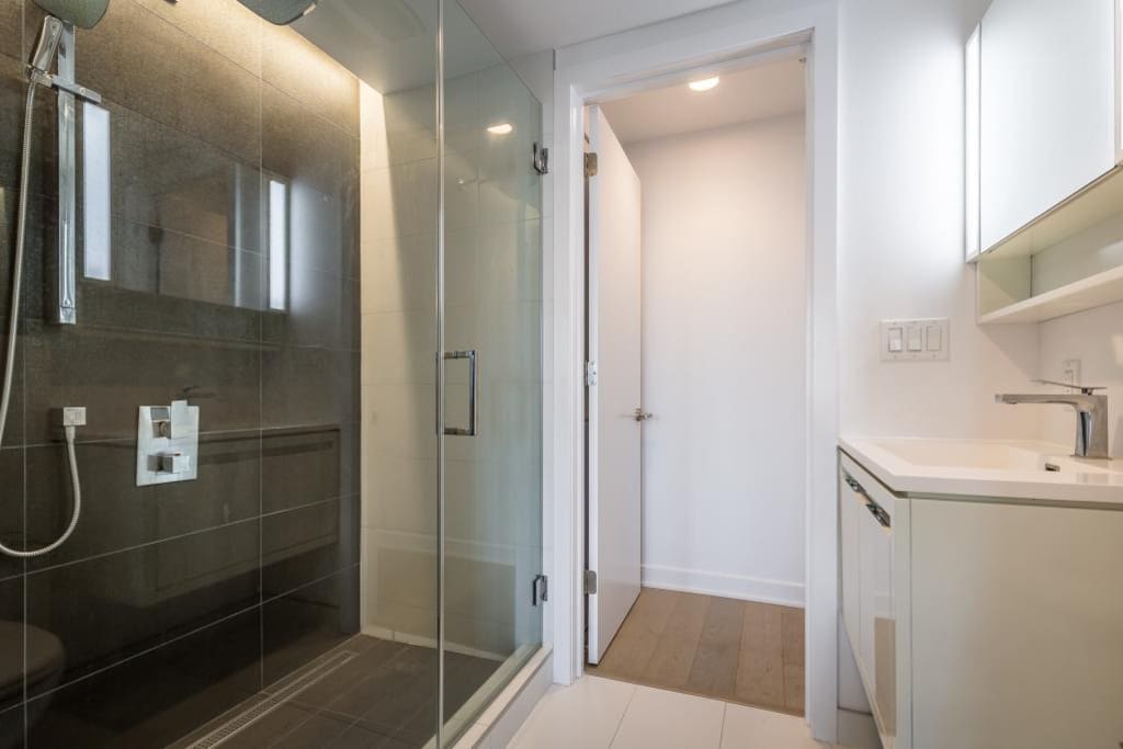 Large walk-in shower with glass door, and rain shower
