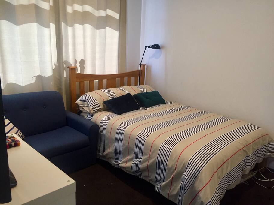 Guest bedroom with comfortable double bed, beautiful cotton linens, 40” flat screen tv and two seat sofa. A selection of books plus notepad, pens, and lap tray laptop desk provided in your room.