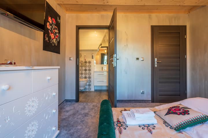 A separate bedroom with a large double bed, a TV and its own bathroom, and a beautiful view of the mountains.