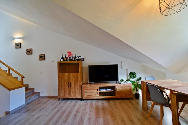 客厅配有餐桌、橱柜和智能电视