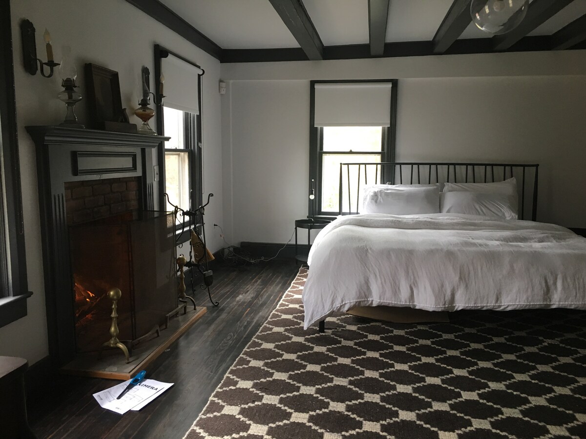 غرفة نوم في الطابق الأول مع مدفأة.