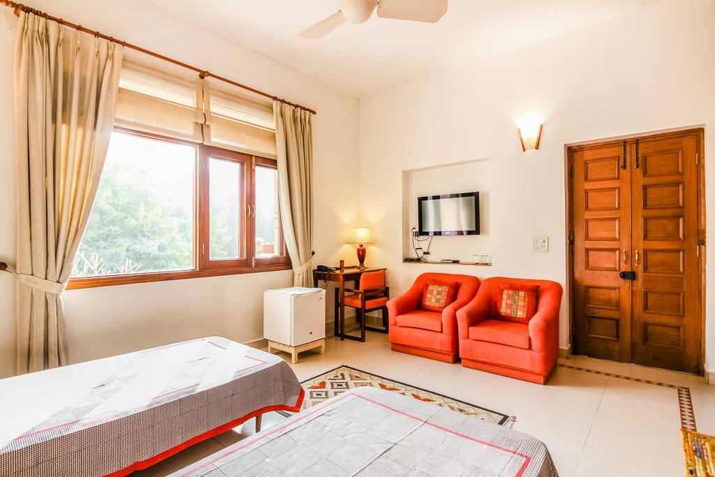 The Large Window allowing ample sunlight in the room + TV + Fridge + 2 single sofas + Study table