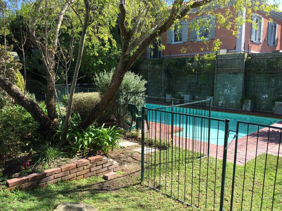The pool is fenced at the bottom of the garden