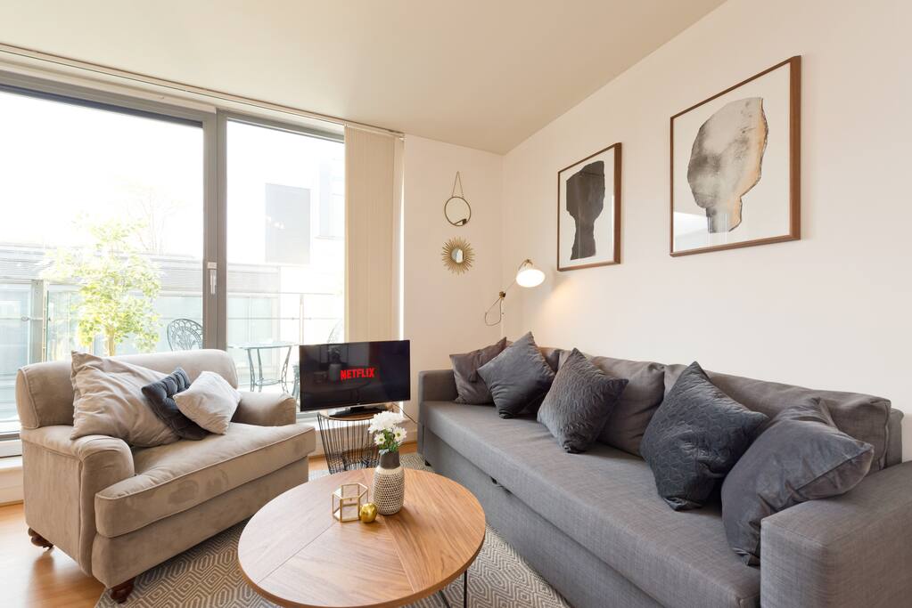 Living area including designer furniture, balcony view and Netflix on the TV