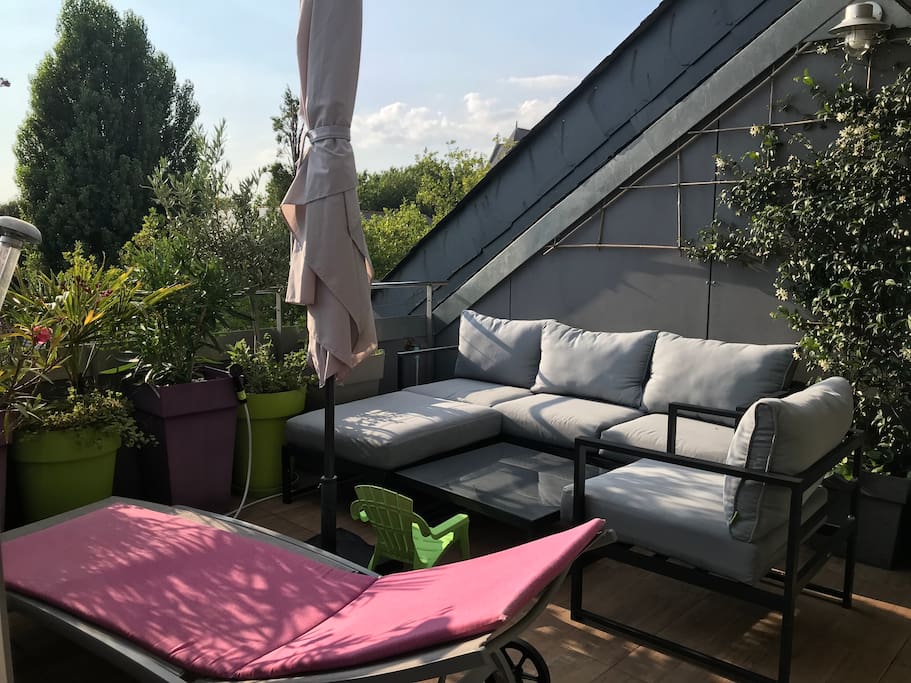 La terrasse : salon de jardin et transat, parasol pour se relaxer à l'ombre !