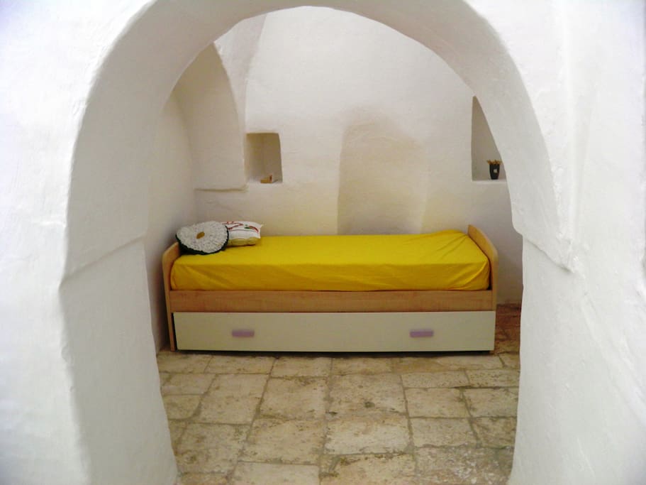 la cameretta nel trullo con il letto estraibile.da notare lo spessore del muro...