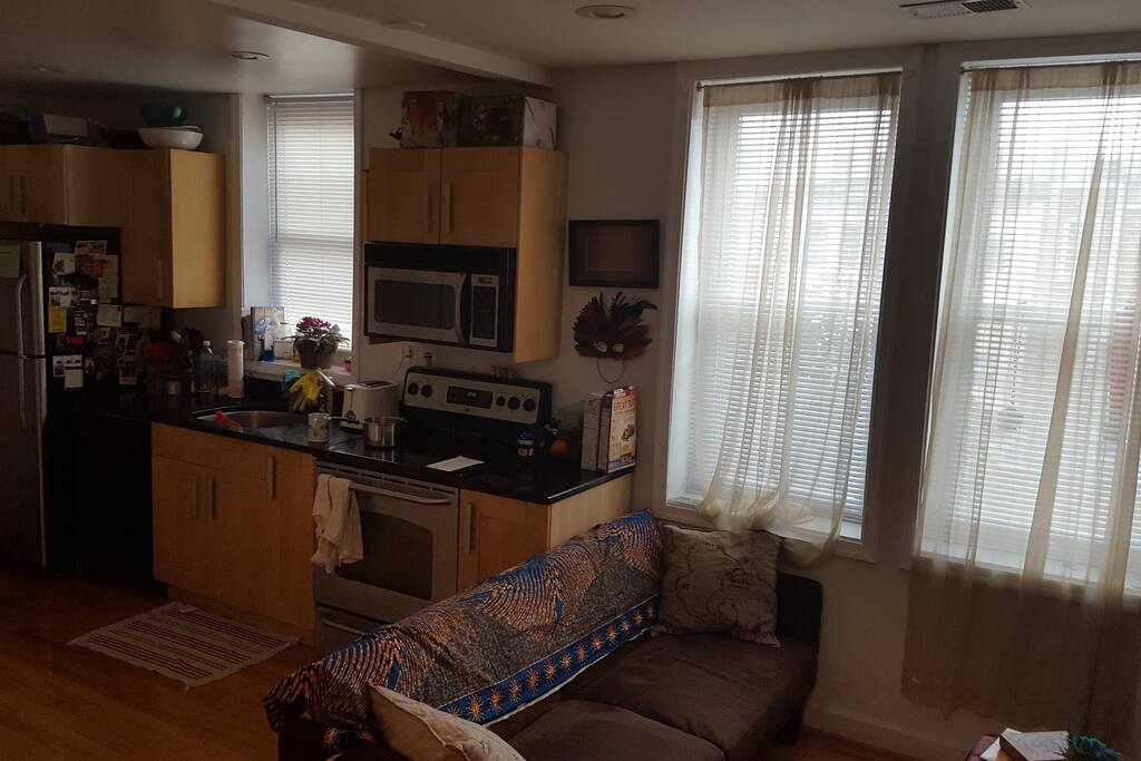 Globally themed living room with futon couch and enough room for an airbed
