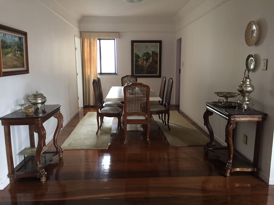 Sala de jantar em mármore travertino com 8 cadeiras em madeira e palhinha natural. Dois aparadores madeira antigo.
Duas passadeiras sob as cadeiras laterais.