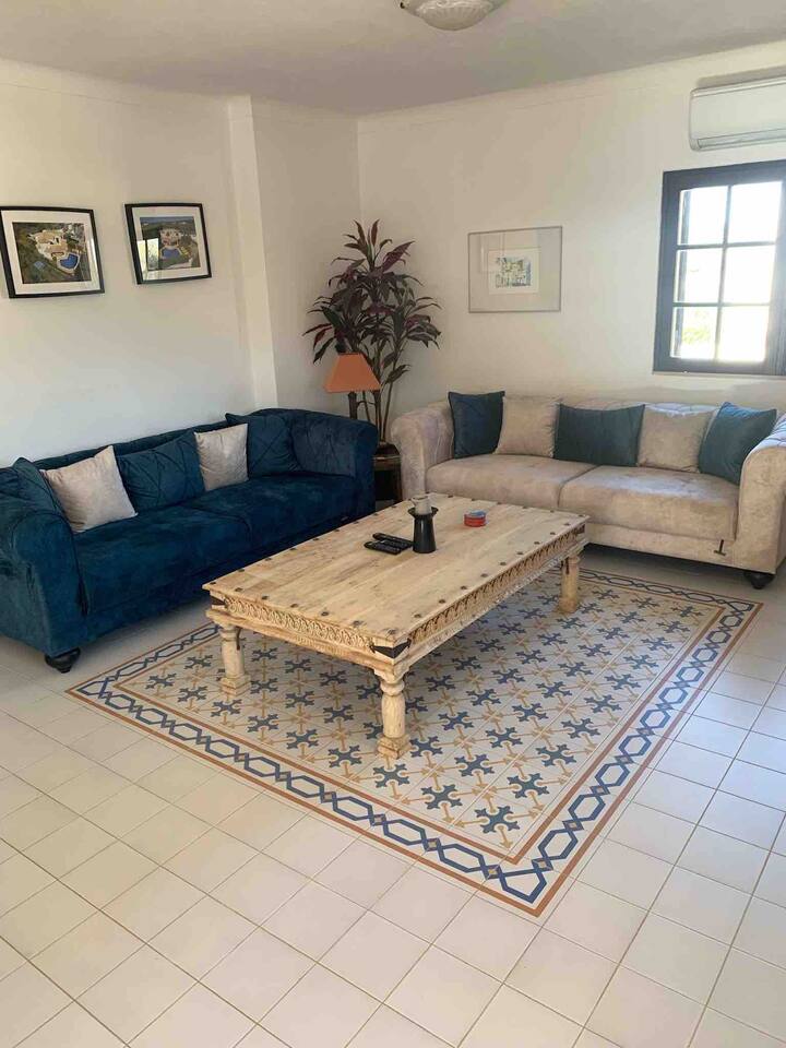 غرفة معيشة تضم سريرين أريكة