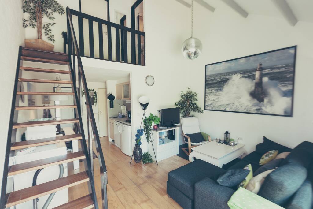 Wohnzimmer mit Blick auf die Galerie und die Küchenzeile mit Essplatz
