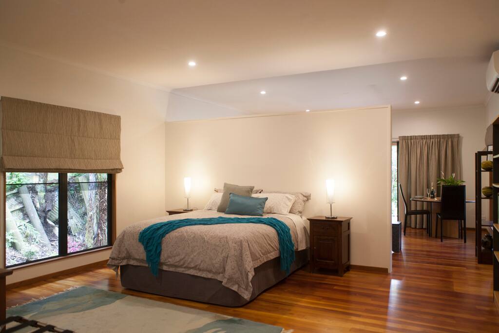 View of the large bedroom and a glimpse of the lounge/dining area