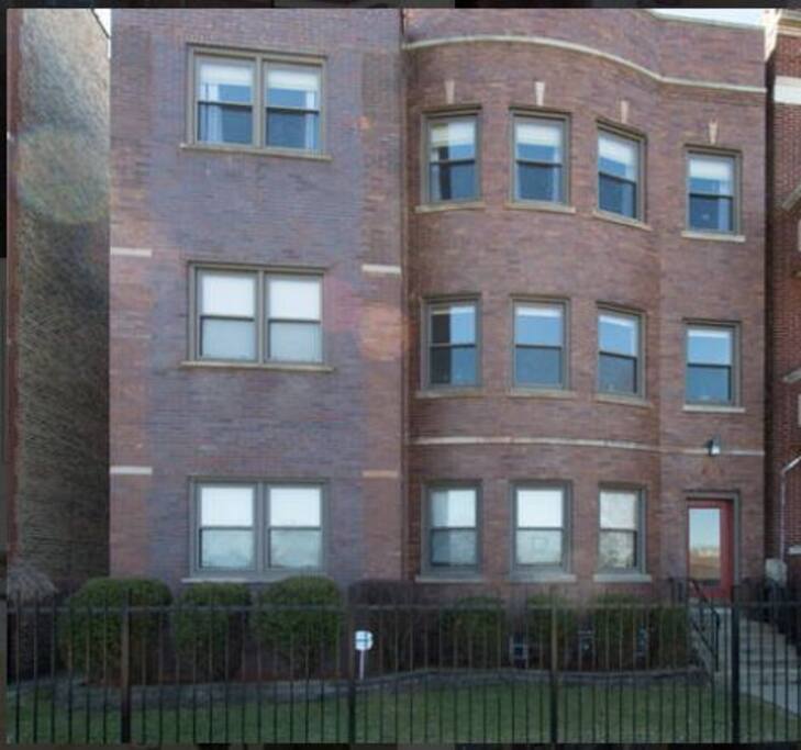 Lovely brick building on a quiet street, manicured landscape with a gated entry.