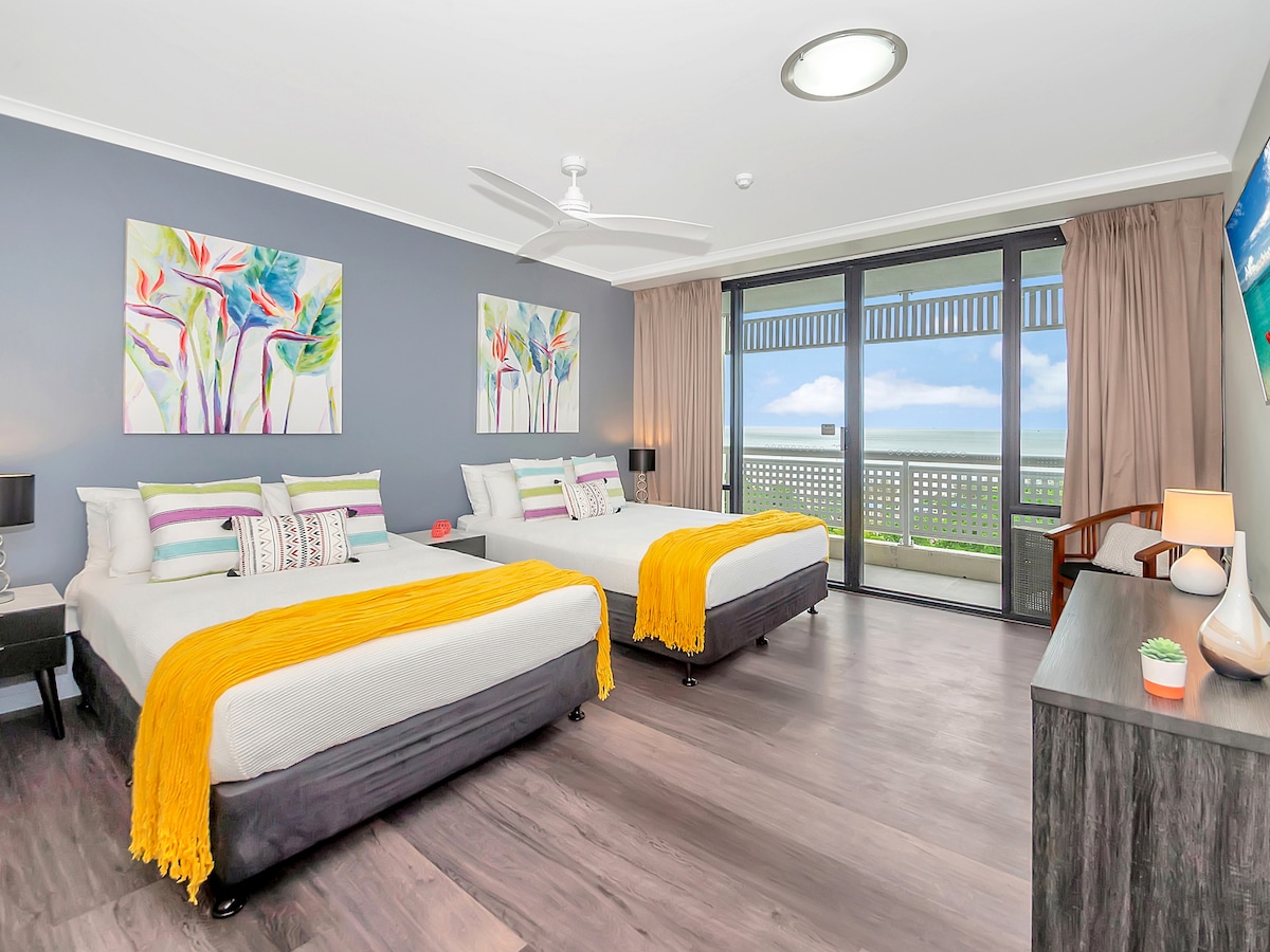 El segundo dormitorio está equipado con una cama tamaño queen y una cama doble. Tiene un televisor montado en la pared y baño privado. 