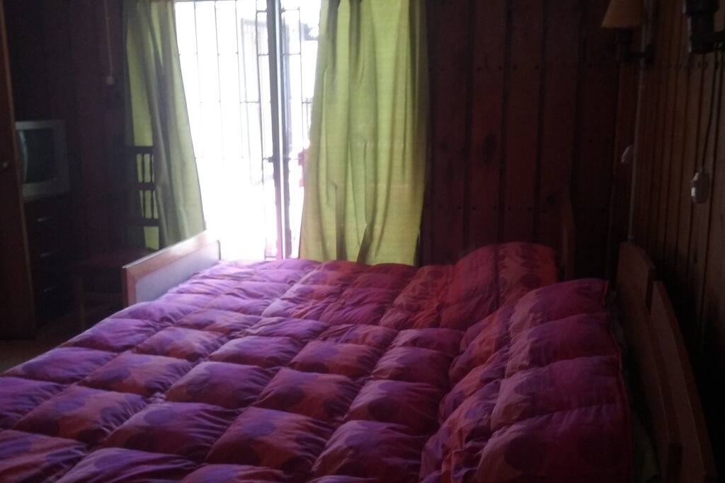 Dormitorio matrimonial con cama de una plaza y media.