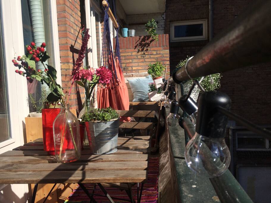 Het balkon met bankje en hangstoel